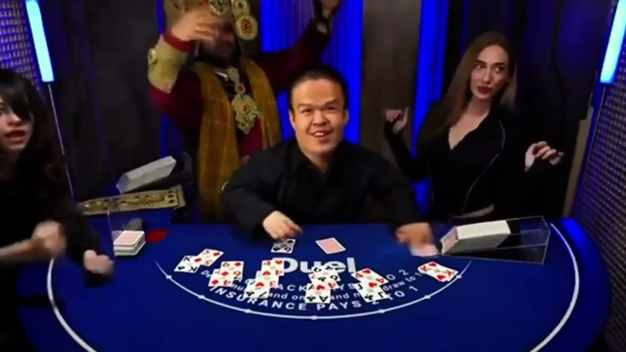 Dancers and a costume behind the dealing position at the Duel blackjack table