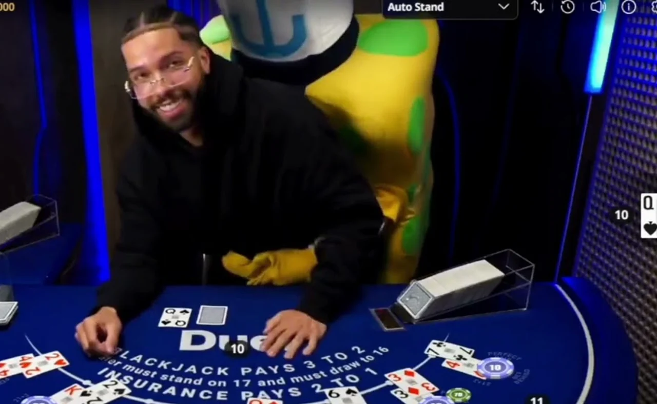 Drake leaning over a live hand at the Duel blackjack table with the costume behind him